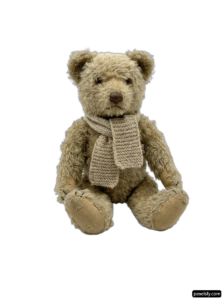 Teddy bear wearing a scarf sitting on a white background png transparent background